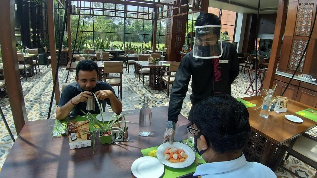 The Orchid Hotel Hinjewadi Пуне Екстер'єр фото A restaurant in India with a waiter wearing a face shield